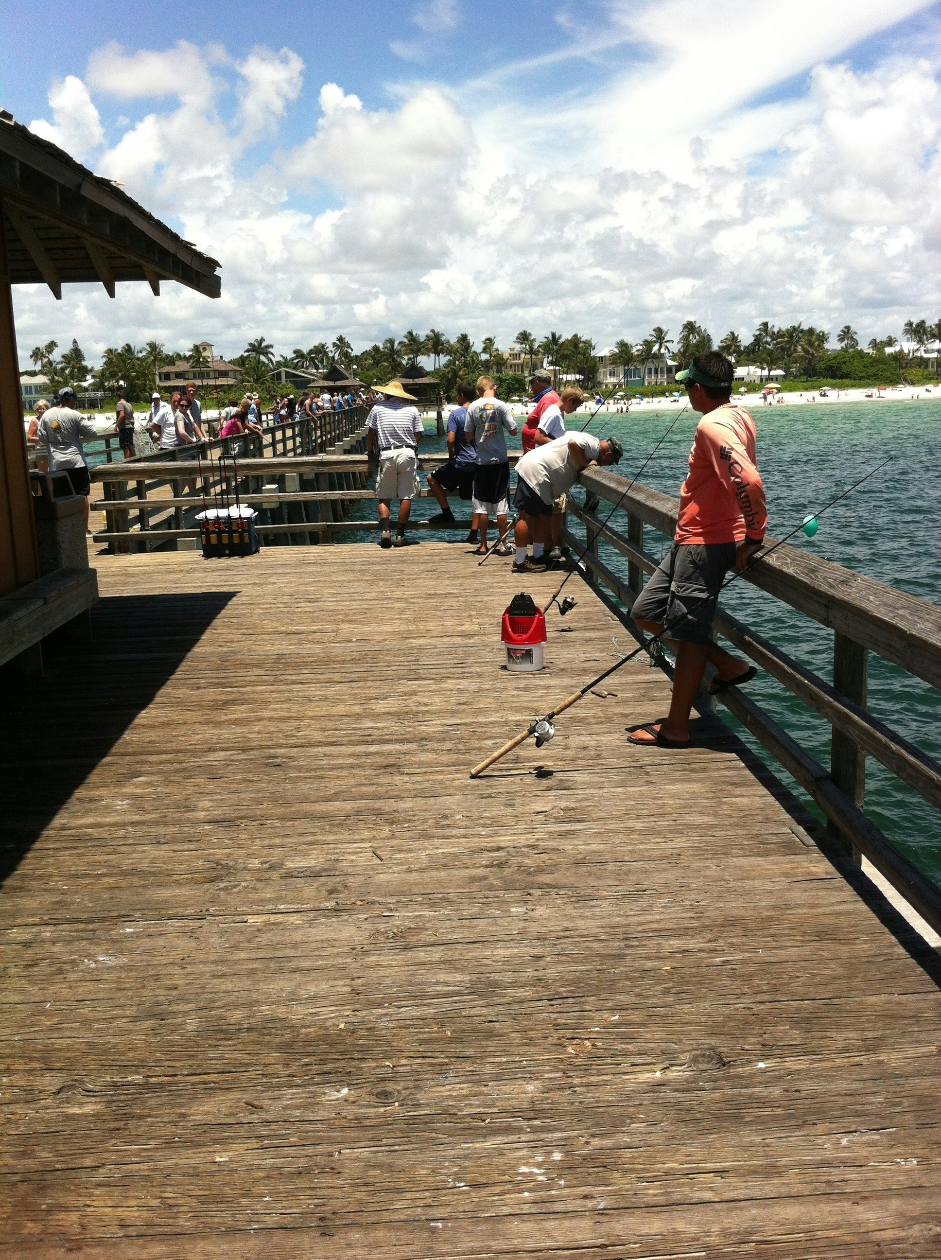 Fishing tournament celebration, trophies, anglers on river dock, tropical setting